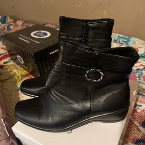 Low heel ladies booties with zip enclosure and silver enhancement at the ankle.